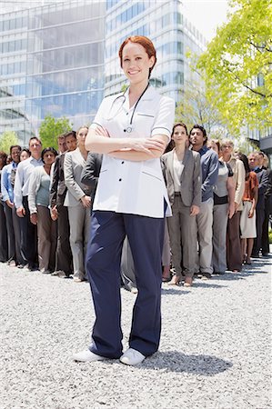 Portrait of confident nurse with business people in background Stock Photo - Premium Royalty-Free, Code: 6113-06499167