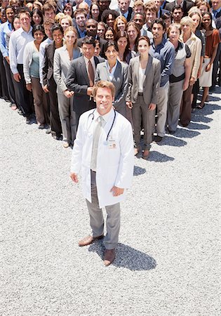 simsearch:6113-06499188,k - Portrait of confident doctor with business people in background Stock Photo - Premium Royalty-Free, Code: 6113-06499171