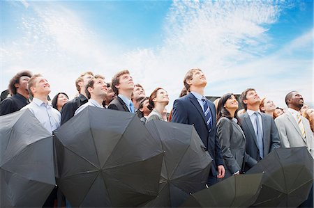 simsearch:6113-06499188,k - Crowd of business people with umbrellas looking up at sky Stock Photo - Premium Royalty-Free, Code: 6113-06499180