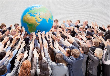 earth day - Crowd of business people reaching for globe Stock Photo - Premium Royalty-Free, Code: 6113-06499188