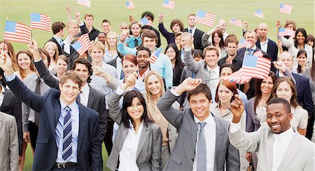 simsearch:6113-06499188,k - Portrait of smiling business people waving American flags overhead Stock Photo - Premium Royalty-Free, Code: 6113-06499199