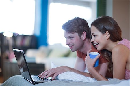 Couple using laptop together on bed Stock Photo - Premium Royalty-Free, Code: 6113-06625558
