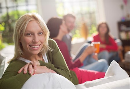 Smiling woman sitting on sofa Stock Photo - Premium Royalty-Free, Code: 6113-06625562