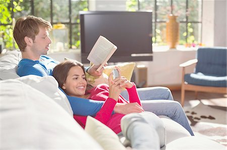 simsearch:6113-07731119,k - Couple relaxing on sofa together Stock Photo - Premium Royalty-Free, Code: 6113-06625615