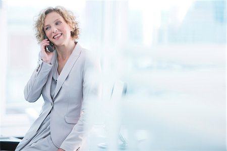 Businesswoman talking on phone in office Stock Photo - Premium Royalty-Free, Code: 6113-06625786