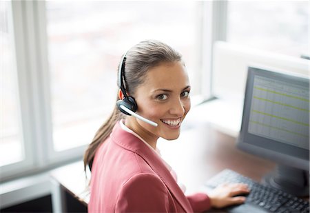 Businesswoman wearing headset at desk Stock Photo - Premium Royalty-Free, Code: 6113-06625727