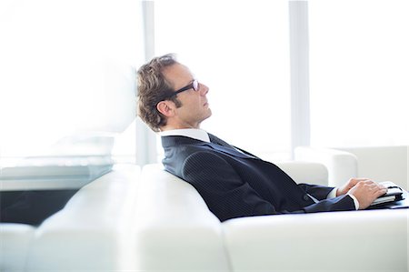 patient sitting in waiting room - Businessman sitting on sofa in office lobby Stock Photo - Premium Royalty-Free, Code: 6113-06625829