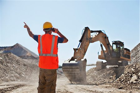 Worker directing digger in quarry Stock Photo - Premium Royalty-Free, Code: 6113-06625971