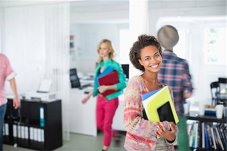 small business wireless - Businesswoman carrying folders in office Stock Photo - Premium Royalty-Free, Code: 6113-06626076