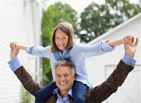 Man carrying granddaughter on shoulders Stock Photo - Premium Royalty-Free, Code: 6113-06626307