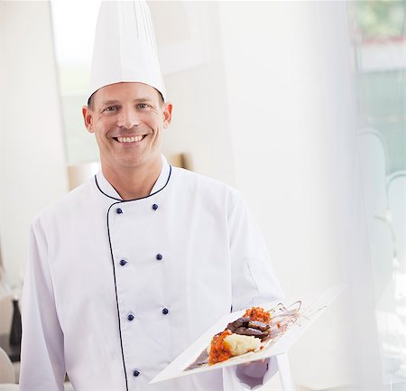 Chef carrying plate of food in restaurant Stock Photo - Premium Royalty-Free, Code: 6113-06626609