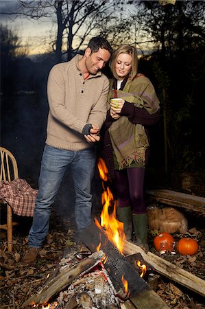 Couple relaxing by campfire at sunset Stock Photo - Premium Royalty-Free, Code: 6113-06626741