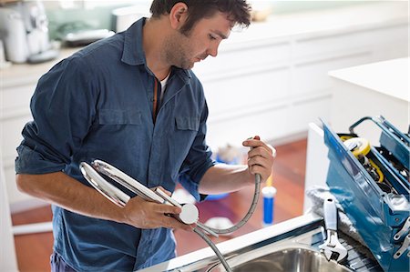 Plumber working on kitchen sink Stock Photo - Premium Royalty-Free, Code: 6113-06753242