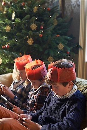 simsearch:6113-06908842,k - Children in paper crowns relaxing on sofa Stock Photo - Premium Royalty-Free, Code: 6113-06753371