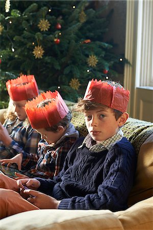 simsearch:6113-06908842,k - Children in paper crowns relaxing on sofa Stock Photo - Premium Royalty-Free, Code: 6113-06753384