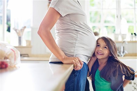 pregnancy - Girl listening to pregnant mother's belly Stock Photo - Premium Royalty-Free, Code: 6113-06753597