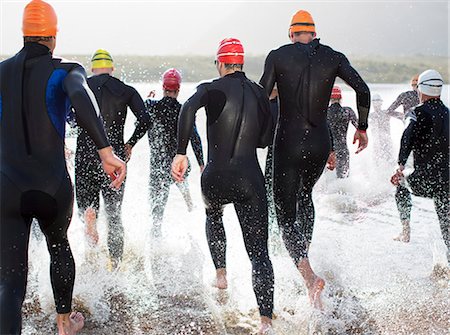 photo man swimming - Triathletes in wetsuits running in waves Stock Photo - Premium Royalty-Free, Code: 6113-06753989