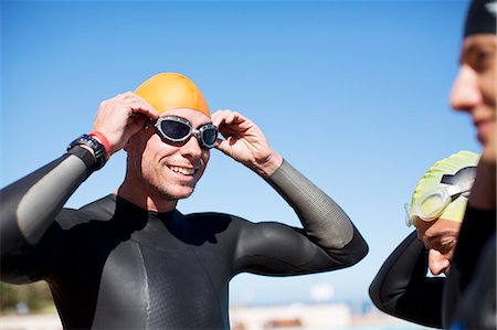 swimming men athletes - Triathlete adjusting goggles outdoors Stock Photo - Premium Royalty-Free, Code: 6113-06754048