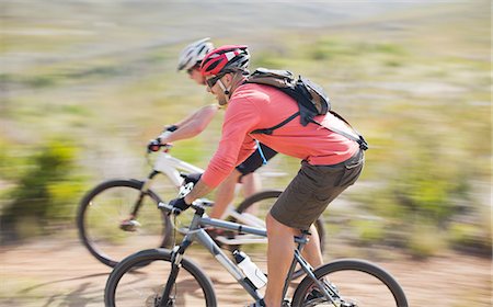 Blurred view of mountain bikers on dirt path Stock Photo - Premium Royalty-Free, Code: 6113-06754176
