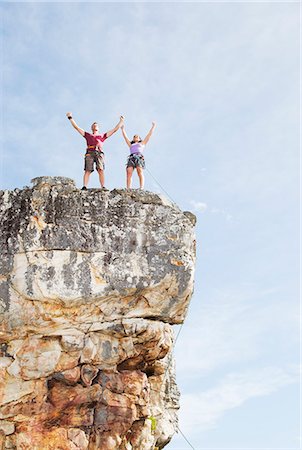 Climbers cheering on rocky cliff Stock Photo - Premium Royalty-Free, Code: 6113-06754107