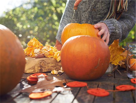 Teenage boy carving pumpkins outdoors Stock Photo - Premium Royalty-Free, Code: 6113-06720257