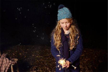 Girl playing with sparkler outdoors Stock Photo - Premium Royalty-Free, Code: 6113-06720221