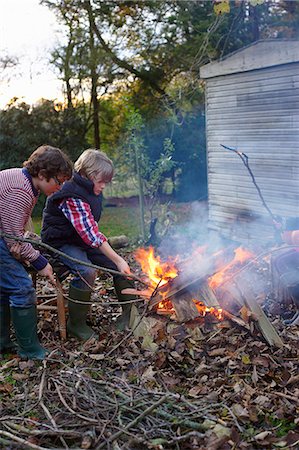 Boys building bonfire outdoors Stock Photo - Premium Royalty-Free, Code: 6113-06720228