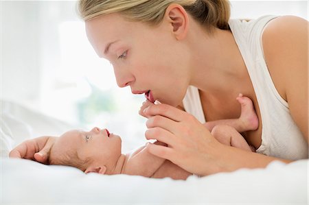 simsearch:6113-06720629,k - Mother cradling newborn infant on bed Foto de stock - Sin royalties Premium, Código: 6113-06720578