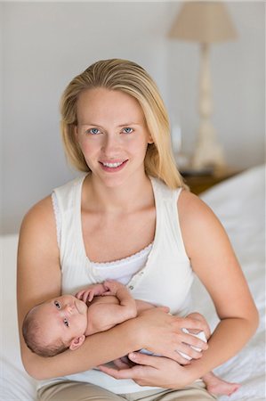simsearch:6113-06720631,k - Mother cradling newborn baby on bed Foto de stock - Sin royalties Premium, Código: 6113-06720669
