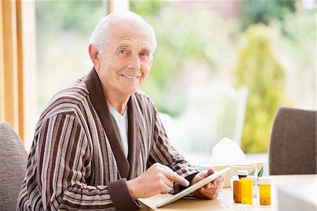 simsearch:6113-06720636,k - Older man using tablet computer at table Stock Photo - Premium Royalty-Free, Code: 6113-06720602