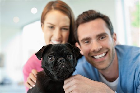 simsearch:6113-06720867,k - Smiling couple petting dog indoors Stock Photo - Premium Royalty-Free, Code: 6113-06720902