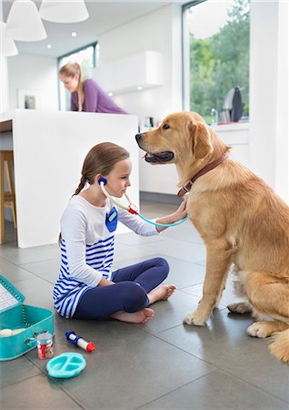 dog on woman - Girl playing doctor with dog in kitchen Stock Photo - Premium Royalty-Free, Code: 6113-06720917