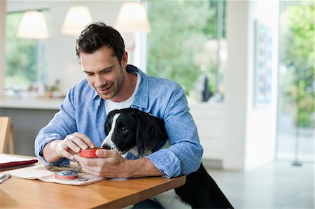 simsearch:6113-06720984,k - Man feeding dog at kitchen table Foto de stock - Sin royalties Premium, Código: 6113-06720929