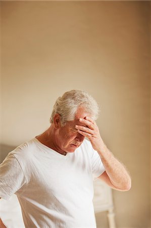Senior man holding head in pain Stock Photo - Premium Royalty-Free, Code: 6113-06898871