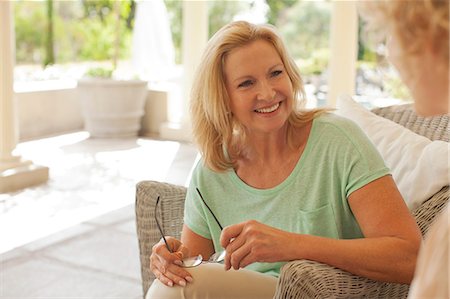 porch wicker - Smiling mother and daughter talking on porch Stock Photo - Premium Royalty-Free, Code: 6113-06898880