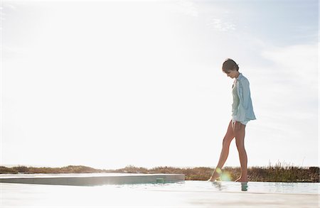 Woman dipping toe in swimming pool Stock Photo - Premium Royalty-Free, Code: 6113-06898948