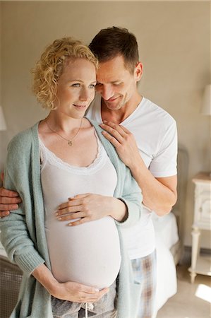 Smiling man hugging pregnant woman Stock Photo - Premium Royalty-Free, Code: 6113-06898900