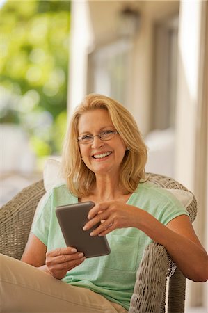 porch wicker - Portrait of smiling woman using digital tablet on porch Stock Photo - Premium Royalty-Free, Code: 6113-06898909