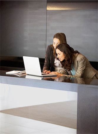 Businesswoman using laptop in lobby Stock Photo - Premium Royalty-Free, Code: 6113-06899013