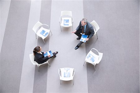 simsearch:6113-06899132,k - High angle view of businessman and businesswoman talking at chairs in circle Stock Photo - Premium Royalty-Free, Code: 6113-06899125