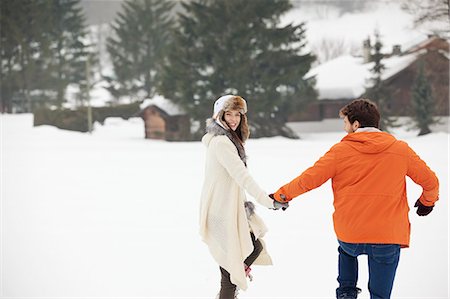 simsearch:6113-07790711,k - Happy couple holding hands and walking in snowy field Photographie de stock - Premium Libres de Droits, Code: 6113-06899347