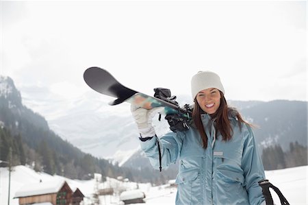 simsearch:6113-06899345,k - Portrait of enthusiastic woman carrying skis in snowy field Stock Photo - Premium Royalty-Free, Code: 6113-06899359