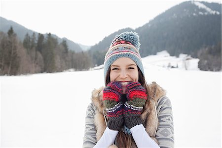 Portrait of enthusiastic woman wearing knit hat and gloves in snowy field Stock Photo - Premium Royalty-Free, Code: 6113-06899374