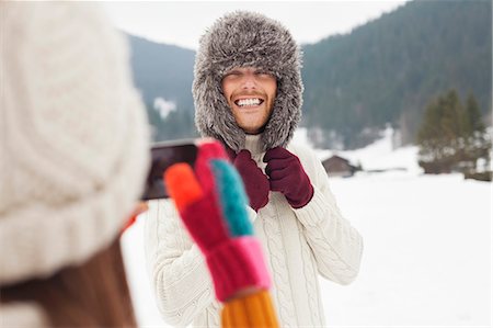simsearch:6113-06899345,k - Woman photographing man wearing fur hat in snowy field Stock Photo - Premium Royalty-Free, Code: 6113-06899321