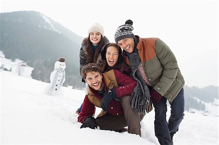 simsearch:6113-06899345,k - Portrait of happy friends in snowy field with snowman Stock Photo - Premium Royalty-Free, Code: 6113-06899325