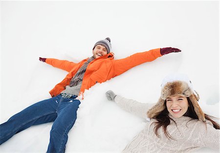 Portrait of happy couple making snow angels Stock Photo - Premium Royalty-Free, Code: 6113-06899330