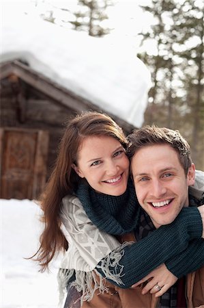 simsearch:6113-06720867,k - Portrait of happy couple hugging in snow outside cabin Stock Photo - Premium Royalty-Free, Code: 6113-06899459