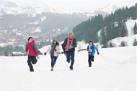 simsearch:6113-06899473,k - Family running in snowy field Stock Photo - Premium Royalty-Free, Code: 6113-06899474