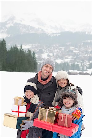 simsearch:6113-06899473,k - Portrait of happy family carrying Christmas gifts in snowy field Stock Photo - Premium Royalty-Free, Code: 6113-06899499