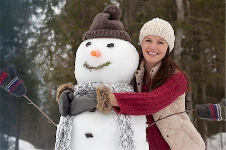 simsearch:6113-06899345,k - Portrait of smiling woman hugging snowman Stock Photo - Premium Royalty-Free, Code: 6113-06899502